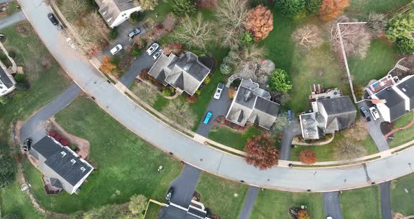 Top down aerial of neighborhood. Curvy road through community. Autumn scene.