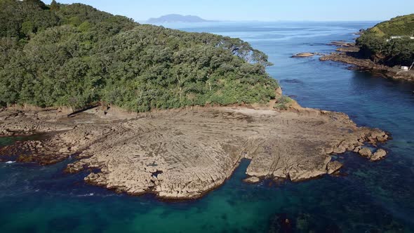 Aerial Pull Backward Revealing Goat Island Picturesque Scenery Of Wrinkleless Ocean And Flat Eroded