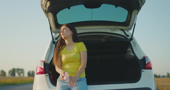 Upset Young Woman Siting in Trunk