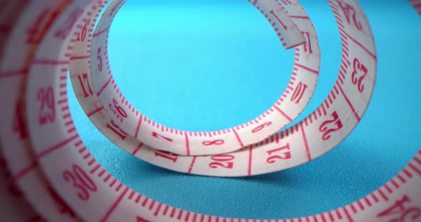 Super Macro Shot of a Measuring Tape Into a Roll of Sewing and Colored Thread on the Background