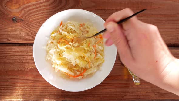 Eating Sauerkraut with vegetable oil. National european dish Pickled cabbage carrot Homemade food