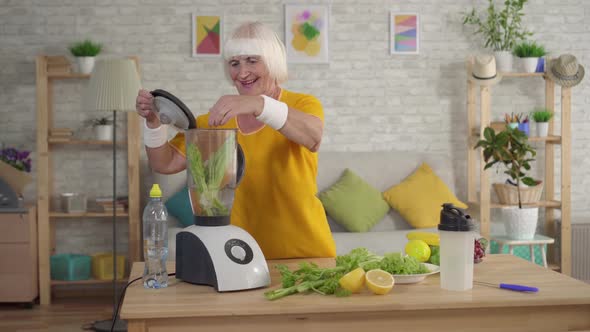 Active Athletic Elderly Woman Throws Celery in the Blender and Makes a Smoothie