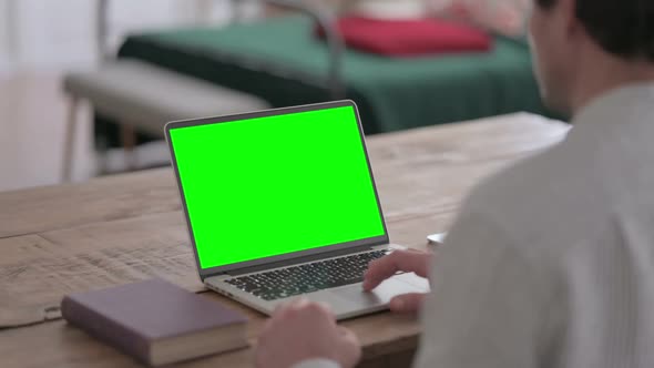 Young Man using Laptop with Green Screen