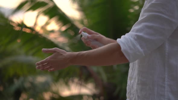 Superslowmotion Shot of a Young Man Applying an Antimosquito Repellent Spray on His Skin