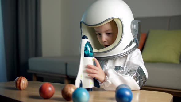 Child Plays at Home in an Astronaut Funny Portrait of a Little Girl 89 Years Old in a Toy Space Suit