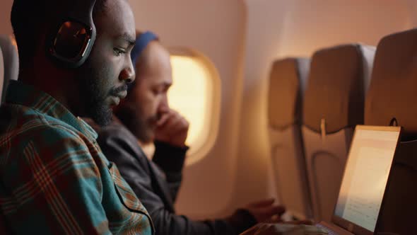 African American Passenger in Airplane Seat Flying on Work Trip