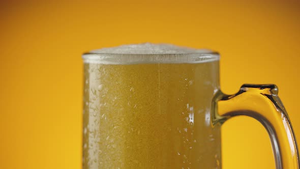 Jet of Beer is Poured Into a Wet Beer Glass with a Lot of Bubbles and Foam