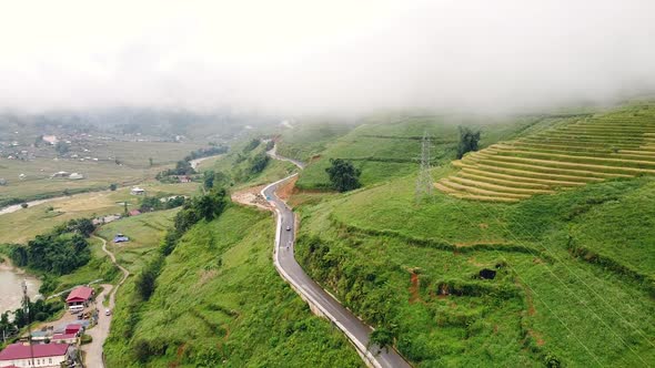 Road on the Hills in the Countryside with Village and Rice Terraces on Foggy Day