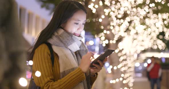 Woman look at mobile phone in city at night