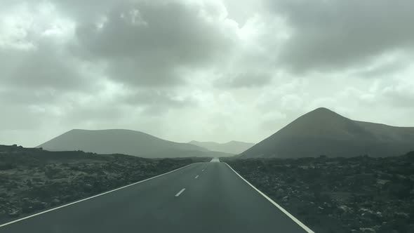 Dash cam point of view driving in Lanzarote with volcanoes. Holiday and tourism footage