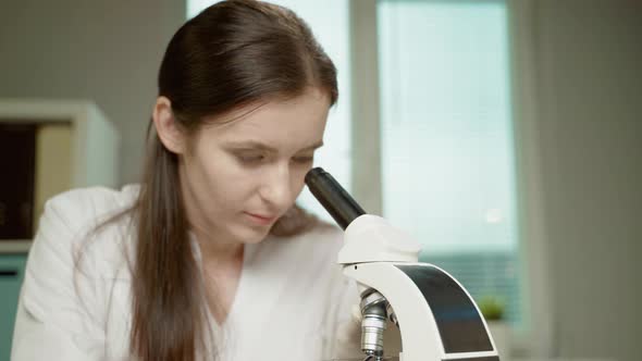 Female Doctor In Laboratory With Microscope alt