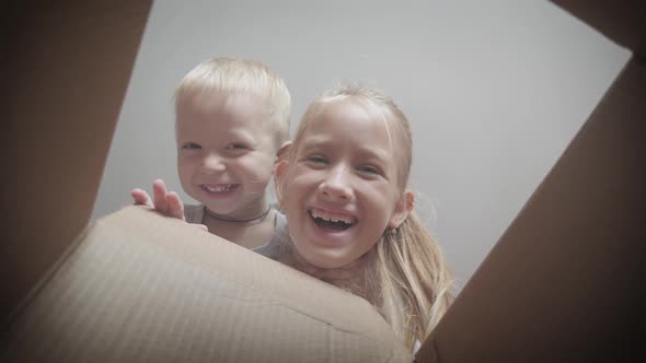 Two Children Looking Into a Box. Happy Children Opening Gifts.