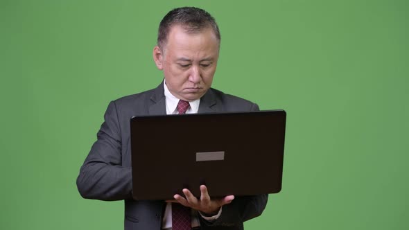 Mature Japanese Businessman Working with Laptop