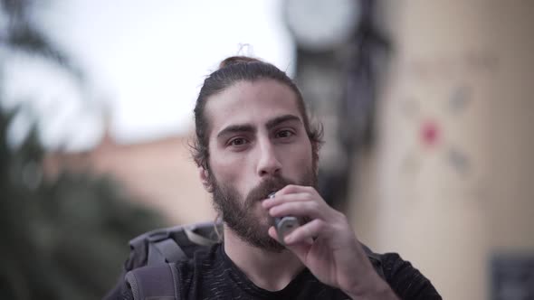 Close Up of a Young Attractive Man Inhaling Vape