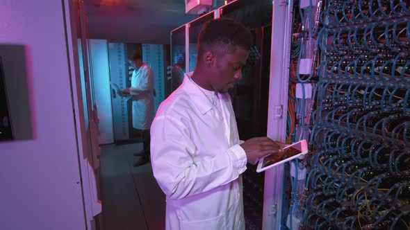 Male IT Specialist Checking Equipment in Data Center