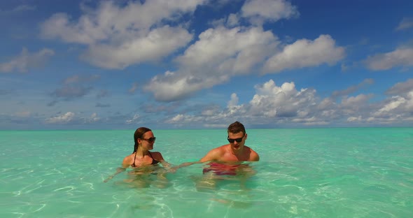 Fun couple married on vacation enjoy luxury on beach on sunny white sandy background 