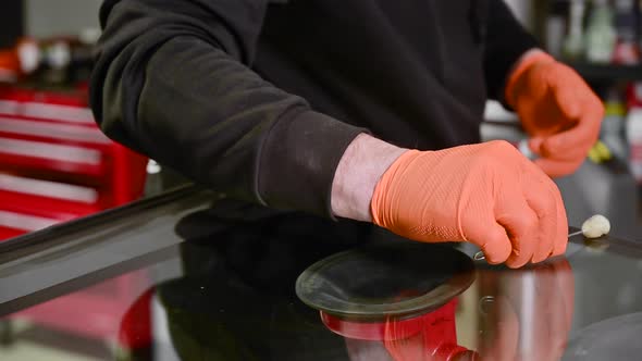 Close Up of Automobile Technician Worker Replacing Windscreen of a Car in Automobile Service Station