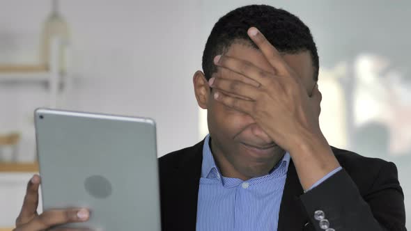 Close Up Of Casual Afro-American Businessman Upset By Loss While Using Tablet