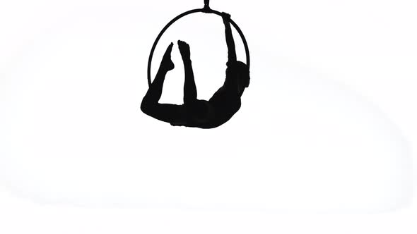 The Black Silhouette of an Aerial Gymnast Performing Acrobatic Tricks and Spinning in the Air on the