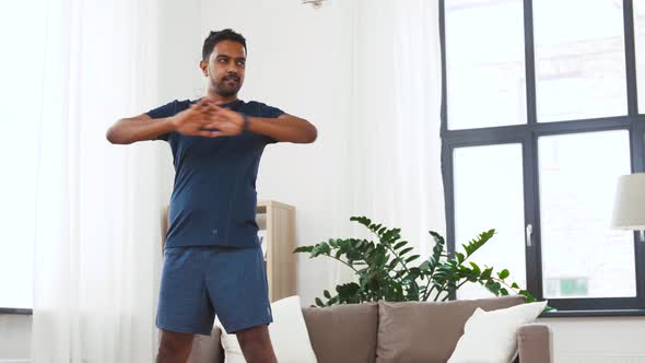 Man with Fitness Tracker Stretching Waist at Home