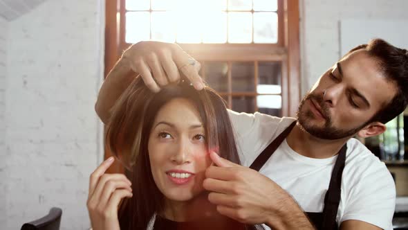 Male hairdresser styling a womans hair