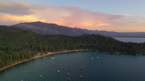 Scenic Landscape Of Lake Tahoe With Boats On The Water During Sunset - aerial drone shot