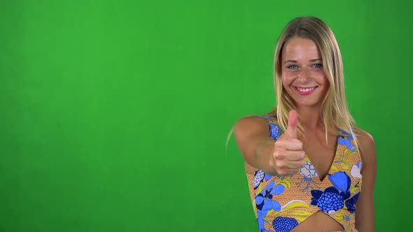 Young Pretty Blond Woman Shows Thumb Up on Agreement - Green Screen - Studio