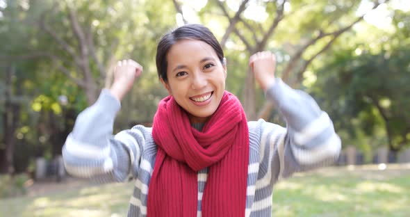 Excited woman cheer up in the city park