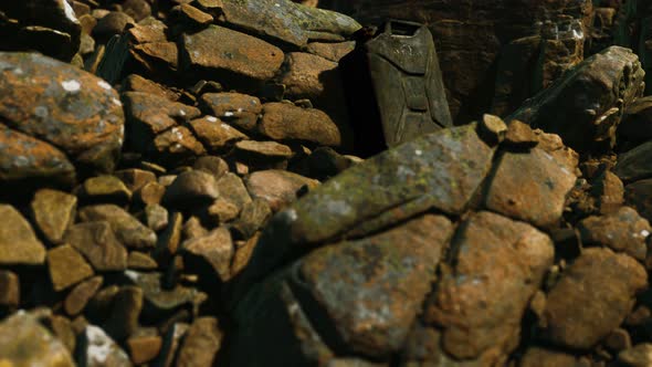 Old Rusty Metal Canister for Gasoline Fuel at Rocks alt
