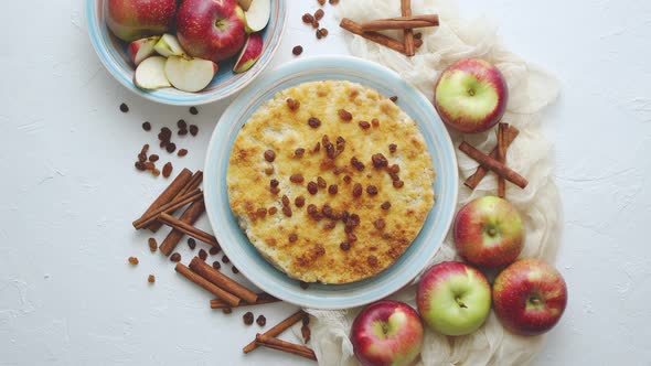 Homemade Apple Cake Pie on Blue Ceramic Plate with Fresh Apples and Cinnamon Sticks