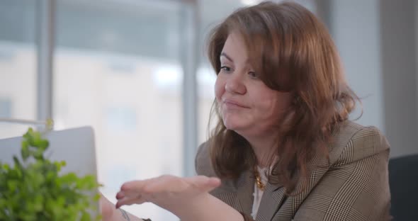 Shocked Businesswoman Looking at Laptop Reading Bad News at Her Desk in Modern Office