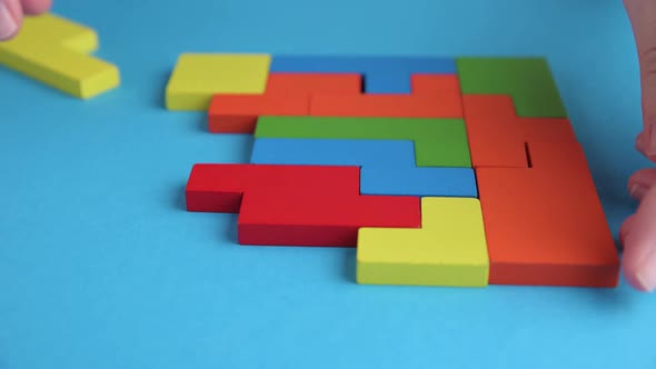 Woman Hand Folds Different Shapes Wooden Blocks to Finish Puzzle