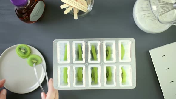 Making kiwi coconut chia popsicles in frozen ice pop maker.