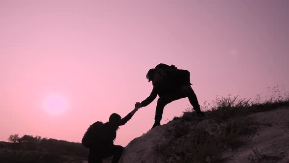 Couple Hiking Help Each Other Silhouette in Mountains. Teamwork Couple Hiking, Help Each Other