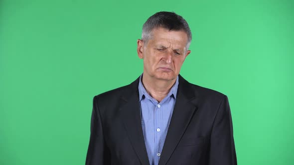 Portrait of Aged Man Is Upset Isolated Over Green Background.