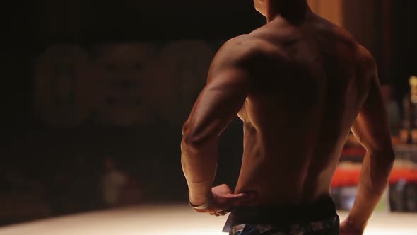 Athletic Man Standing on Stage and Demonstrating Muscular Body at Sports Contest