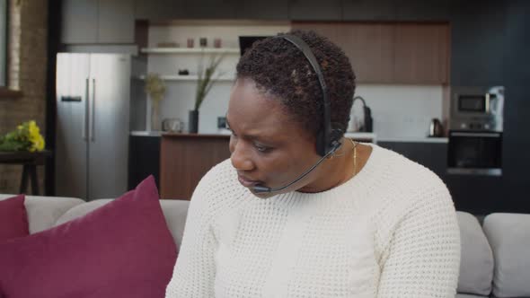 Black Female in Headset Having Video Conference at Home