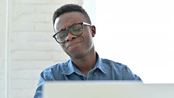 Disappointed Young African Man reacting to Loss on Laptop