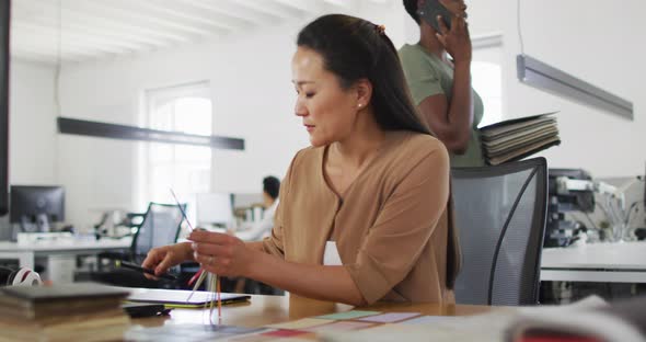 Happy asian businesswoman making notes in office