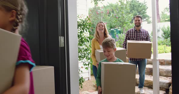 Family with cardboard, boxes entering in a comfortable home 4k