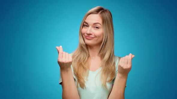 Young Woman Showing Gesture of Wasting Money Against Blue Background Materialist Shopping Concept