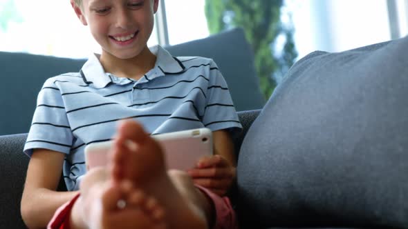 Boy using digital tablet in living room alt