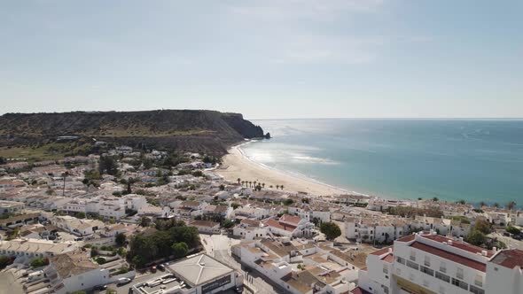 Urbanised village of Praia da Luz, Lagos, Algarve. Sunny sand beach and emerald ocean