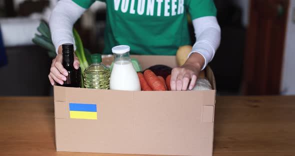 Volunteer preparing food box for ukrainian war refugees