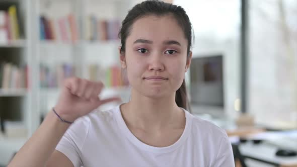 Portrait of Thumbs Down By Young Asian Woman