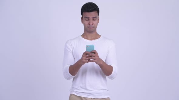 Happy Young Indian Man Using Phone