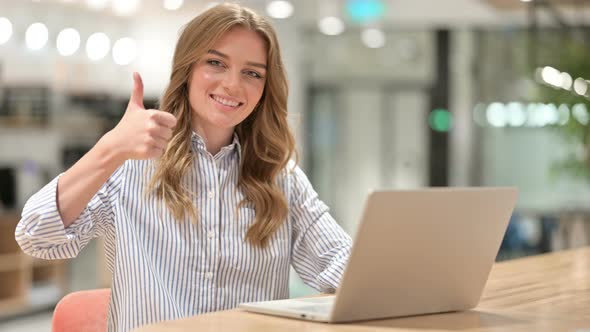 Appreciative Businesswoman with Laptop Doing Thumbs Up