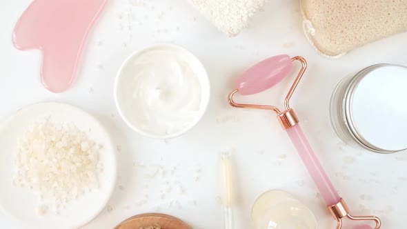 Rotation of Pink Quartz Facial Roller and Glass Bottle with Pipette with Gel Fluid Collagen Serum