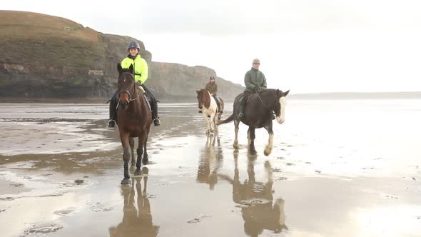 People riding horses on the beach