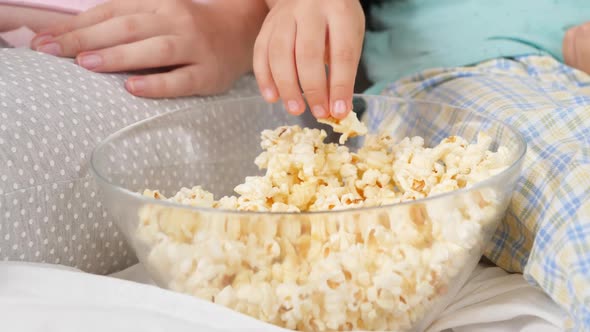 CLoseup of Family Eating Popcorn From Big Bowl